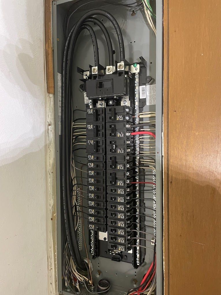 A close up of a electrical panel with a lot of wires coming out of it.