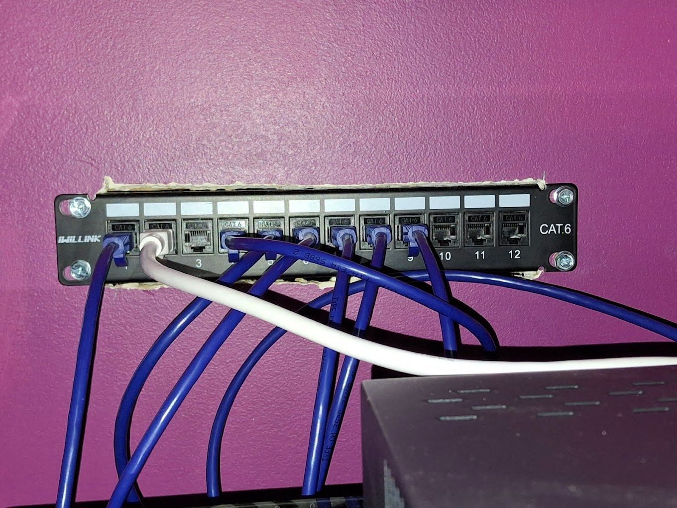 A bunch of blue wires are connected to a purple wall