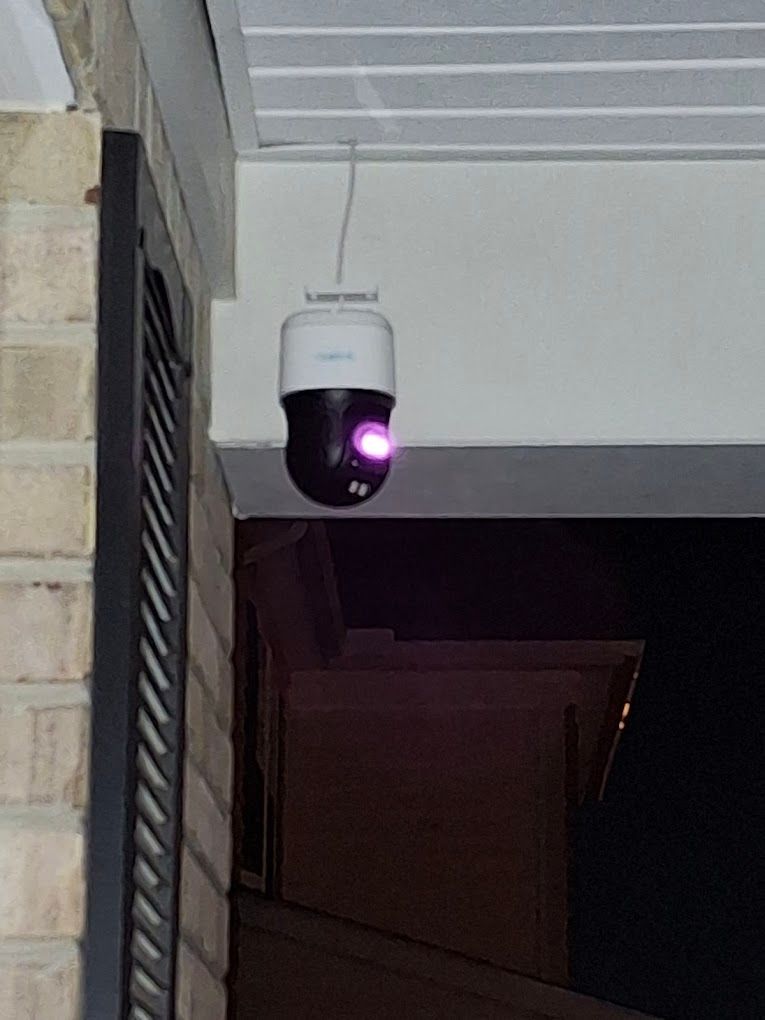 A security camera is hanging from the ceiling of a building.