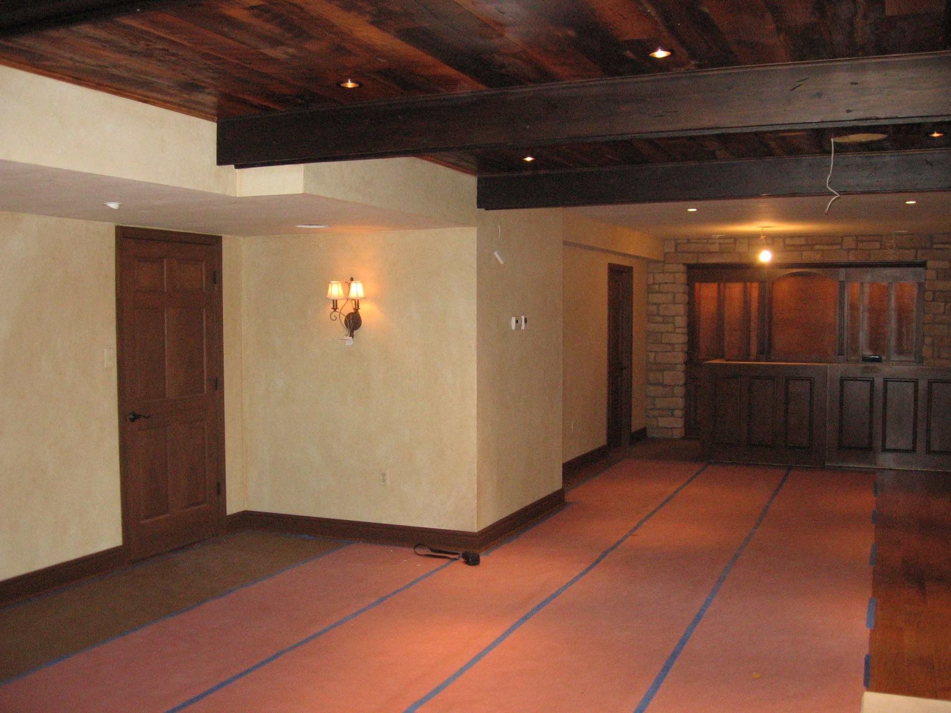 An empty room with a brick wall and wooden beams.