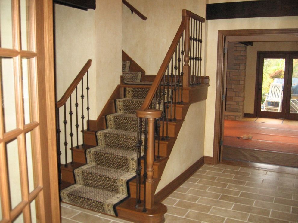 A wooden staircase with a leopard print carpet.