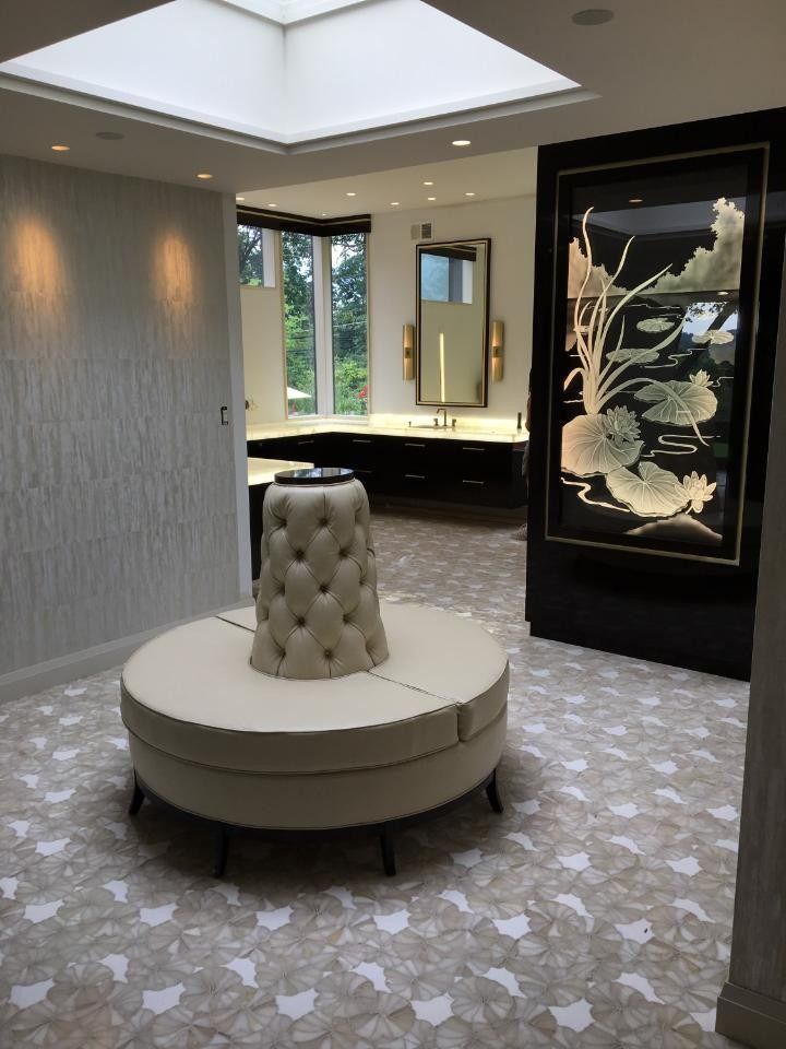 A room with a round couch and a picture on the wall.