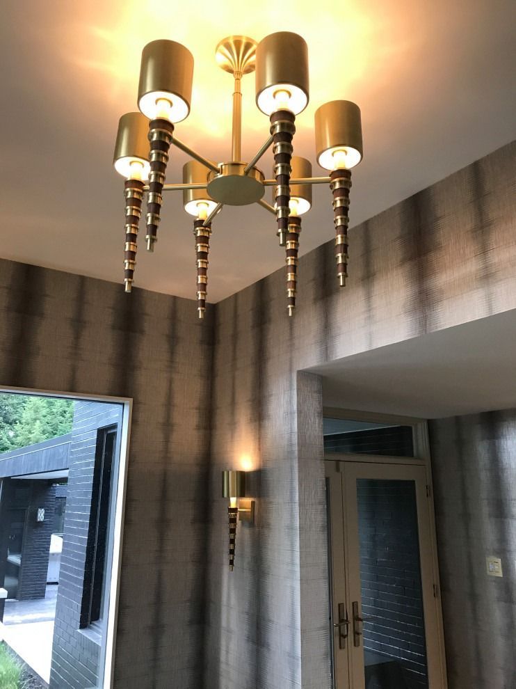 A chandelier is hanging from the ceiling in a hallway.