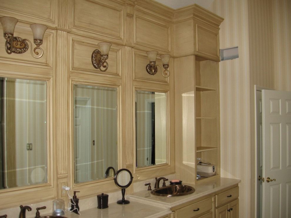 A bathroom with a sink, mirrors, and cabinets.