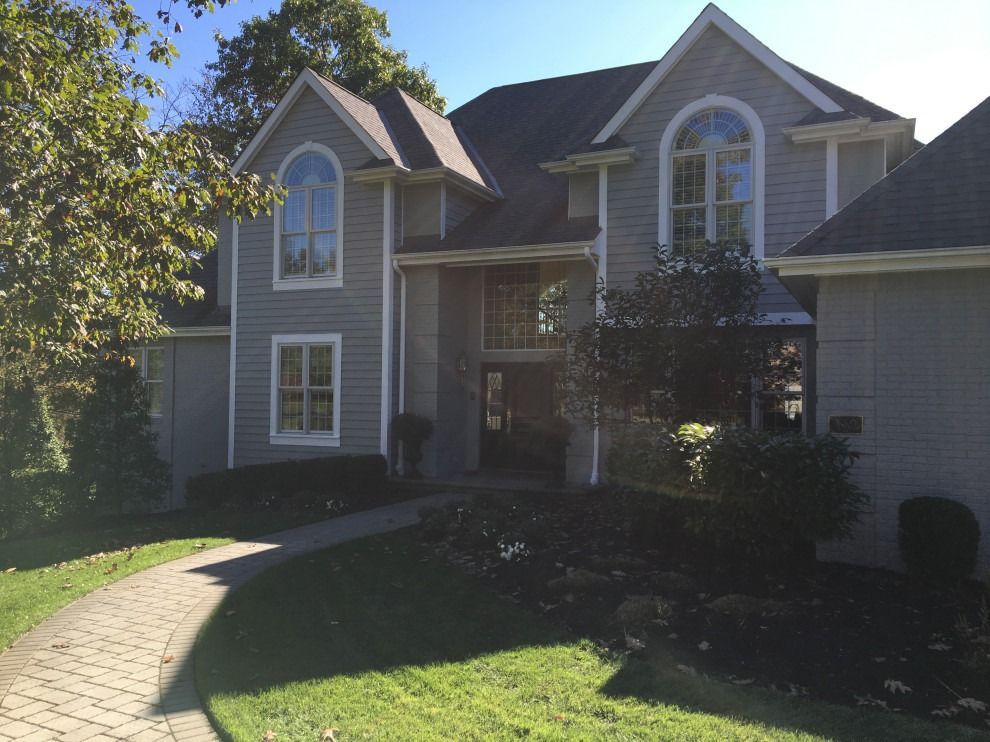 A large house with a brick walkway leading to it.
