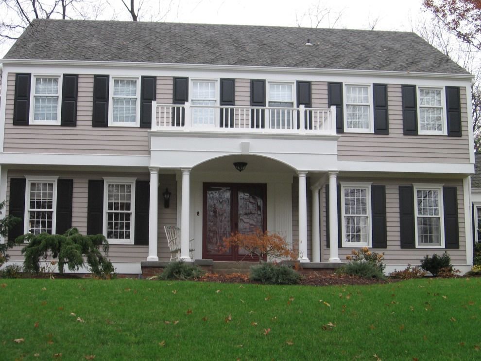 A house with black and white shutters on the windows.