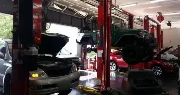 A car is sitting on a lift in a garage.