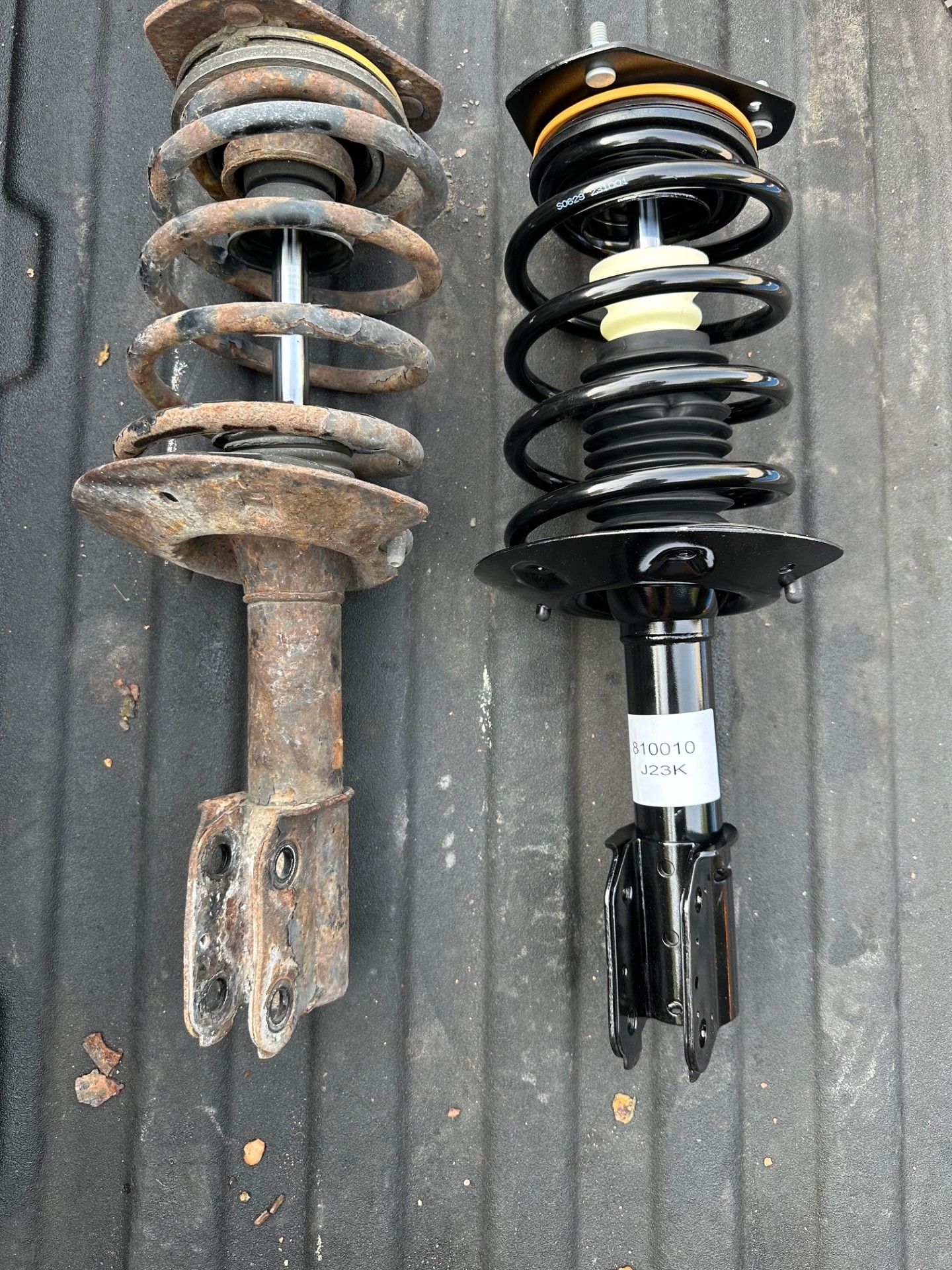 Comparison of old, rusty car strut assembly and new, black assembly | Campbell’s Fix All LTD