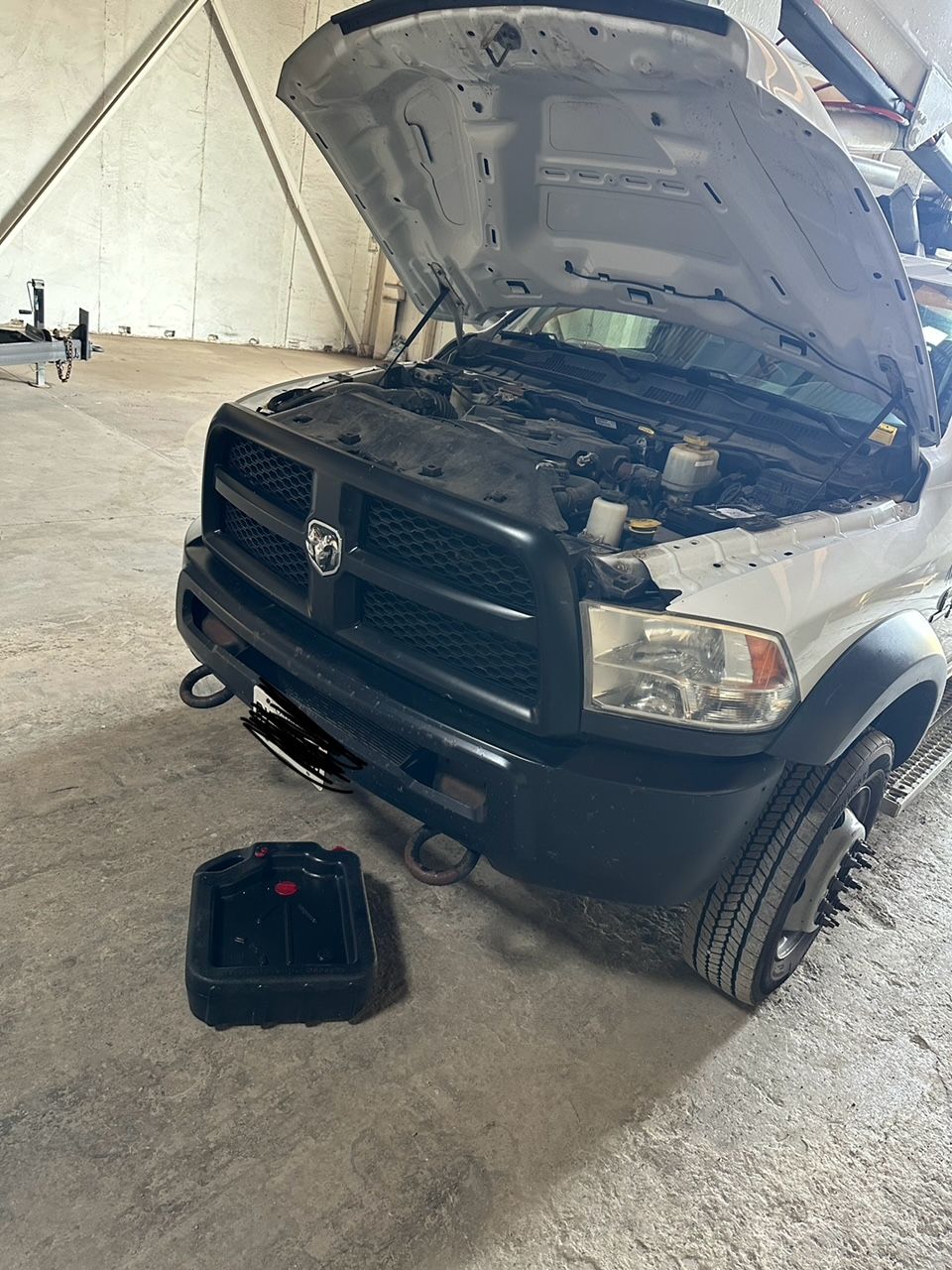 White Ram truck with hood up, oil drain pan below, in a garage | Campbell’s Fix All LTD