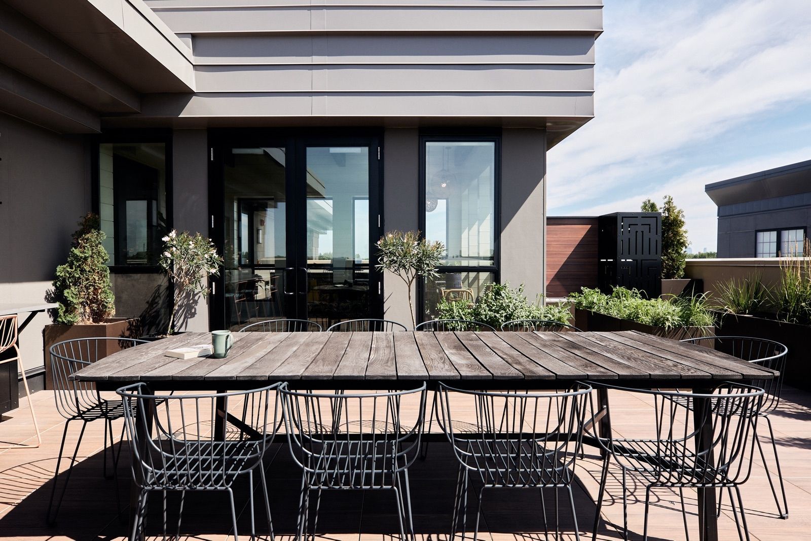 Rooftop dining area features a pass-through window to the kitchen inside