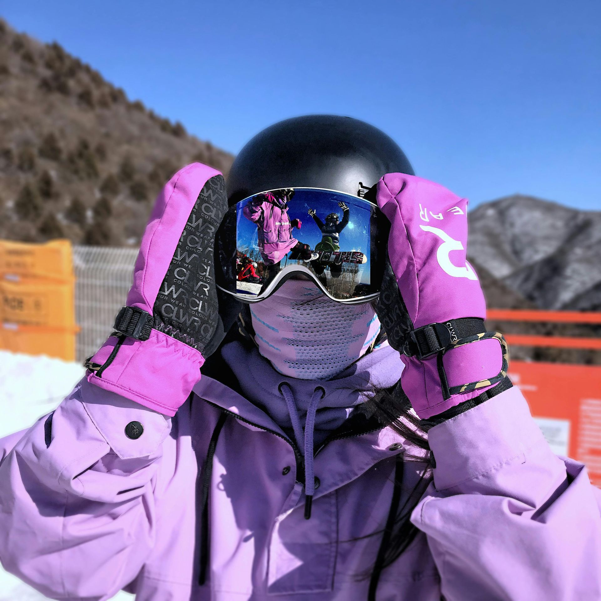 A person wearing purple gloves and goggles