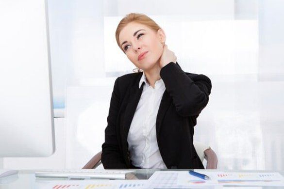 A woman in the office having neck pain — Jersey City, NJ — Pain and Disability Institute