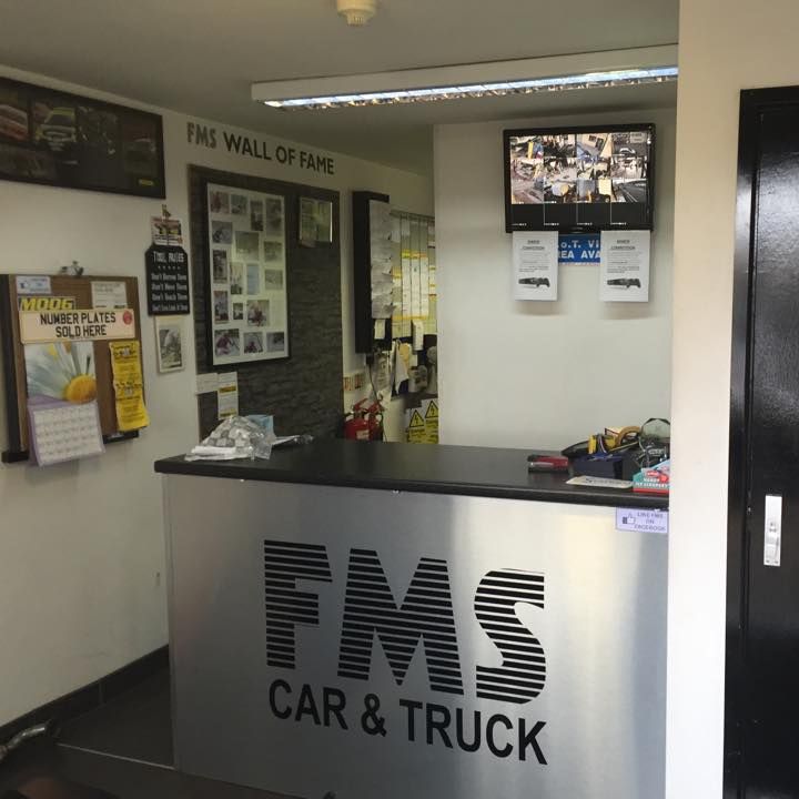 A blue car is sitting on a lift in a garage.