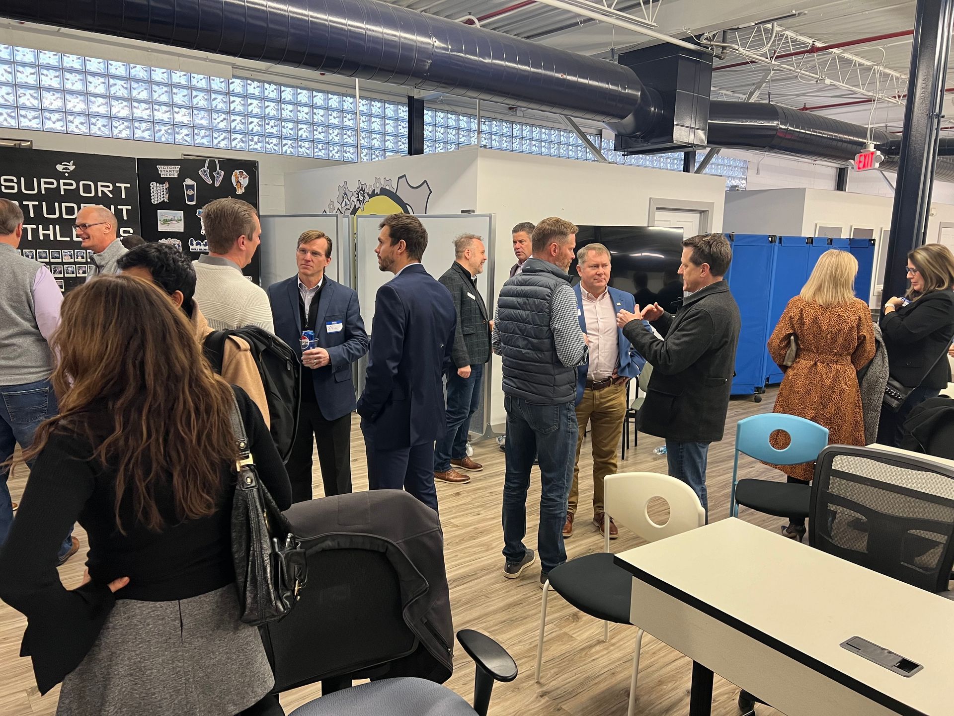 People networking in a modern office. Men and women in business attire, chatting and socializing.