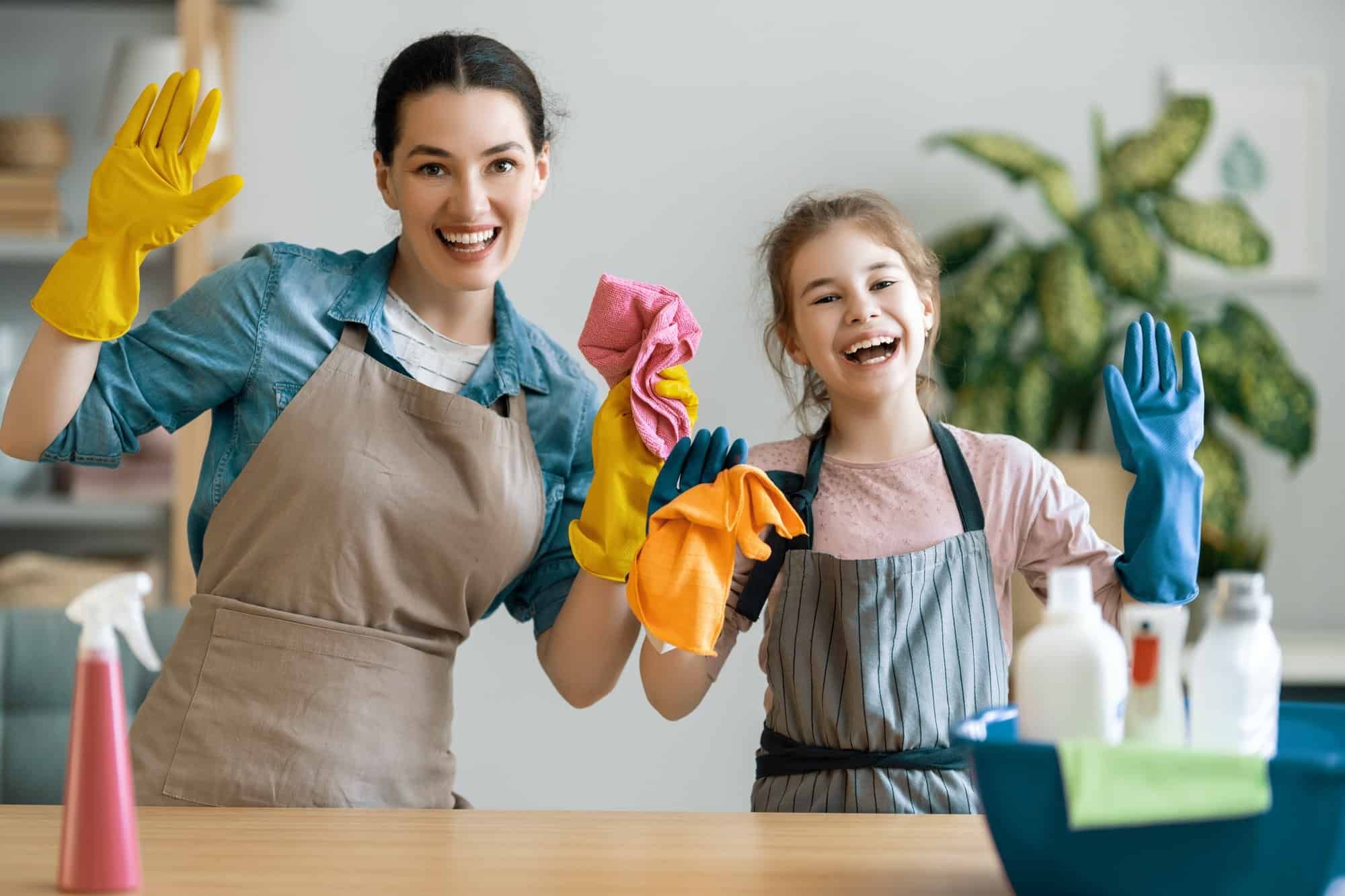 A woman and a little girl are cleaning the house together.