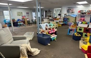 A large room filled with lots of toys and a chair.
