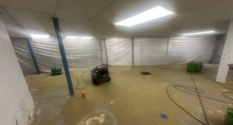 A flooded basement with a vacuum cleaner in it.