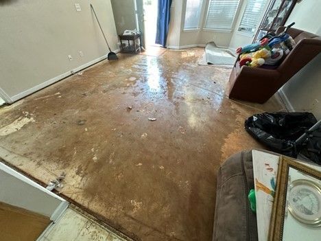 A living room with a dirty floor and a couch.