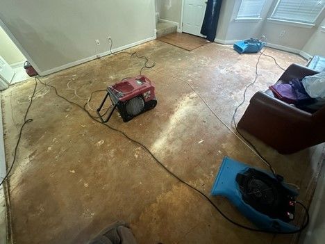 A living room with a chair and a fan on the floor.