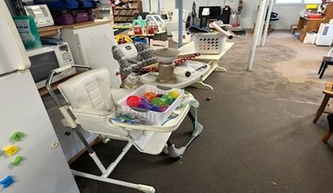 A room filled with lots of toys and a high chair.