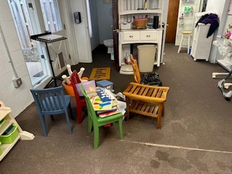 A room with a lot of chairs and toys on the floor.