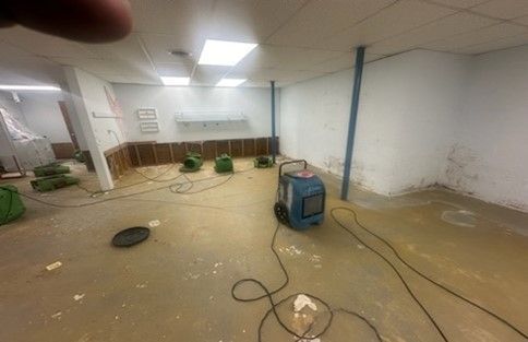 A flooded basement with a vacuum cleaner in it.
