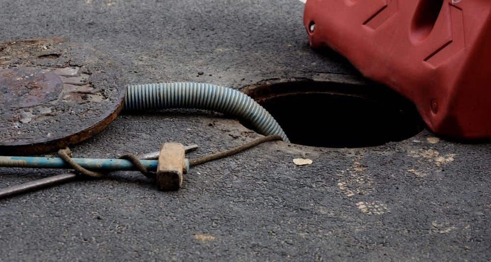 A Manhole Cover With a Hose Coming Out of It — Paul Jennings in Tablelands, QLD