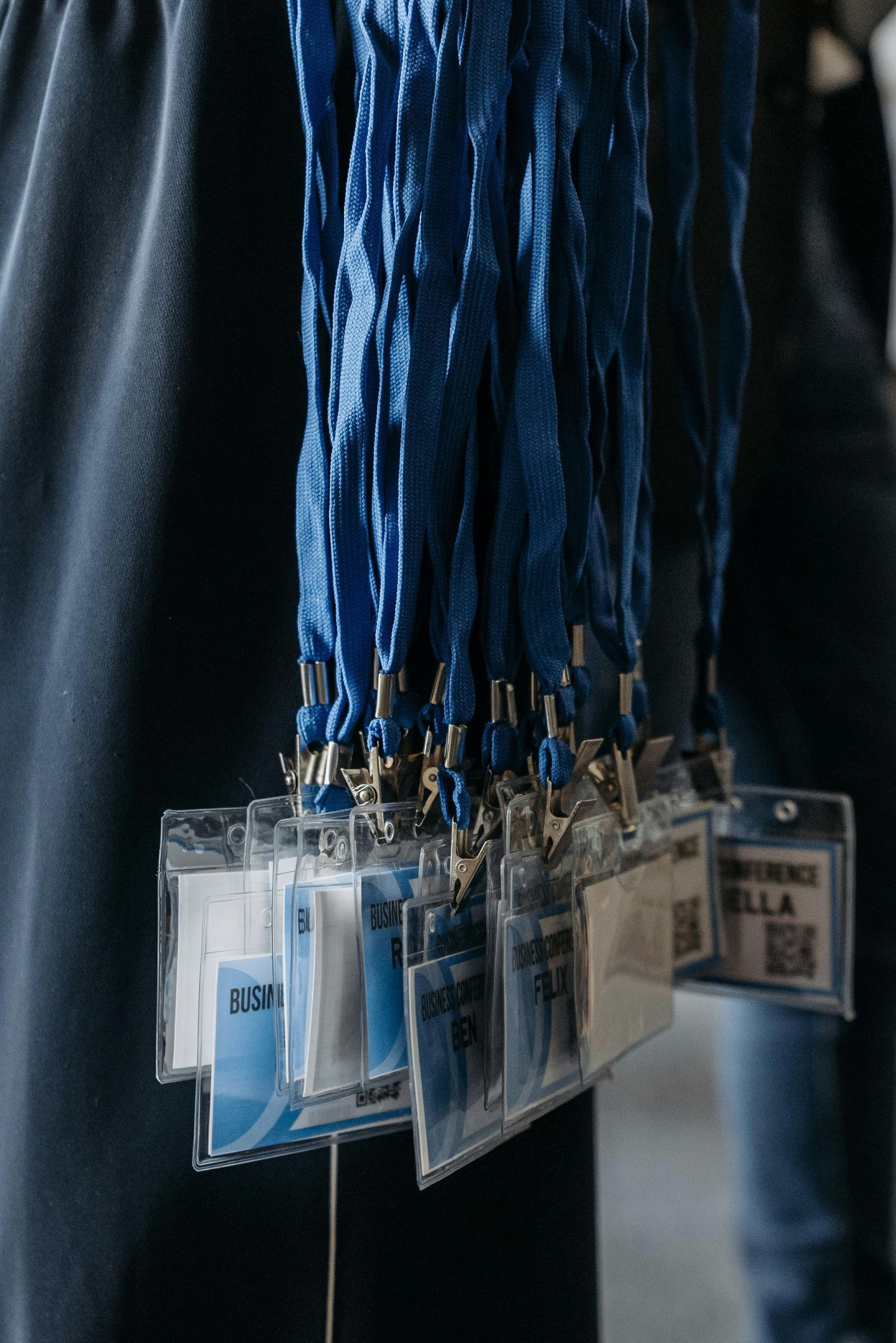 A person is holding a bunch of blue lanyards hanging from their waist.