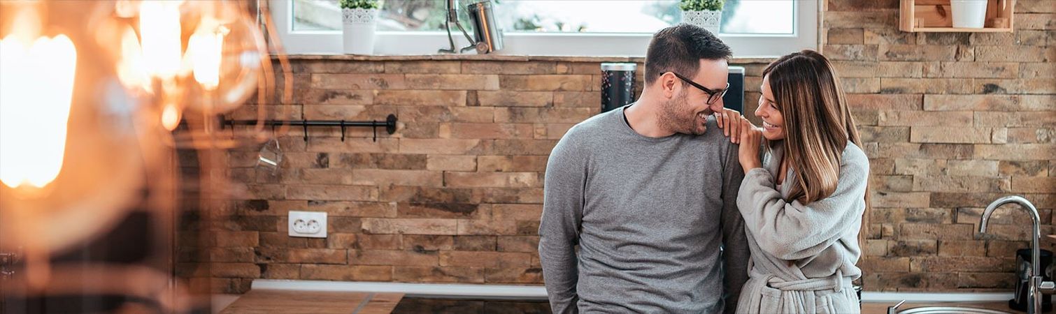 A man and a woman are standing next to each other in a kitchen.