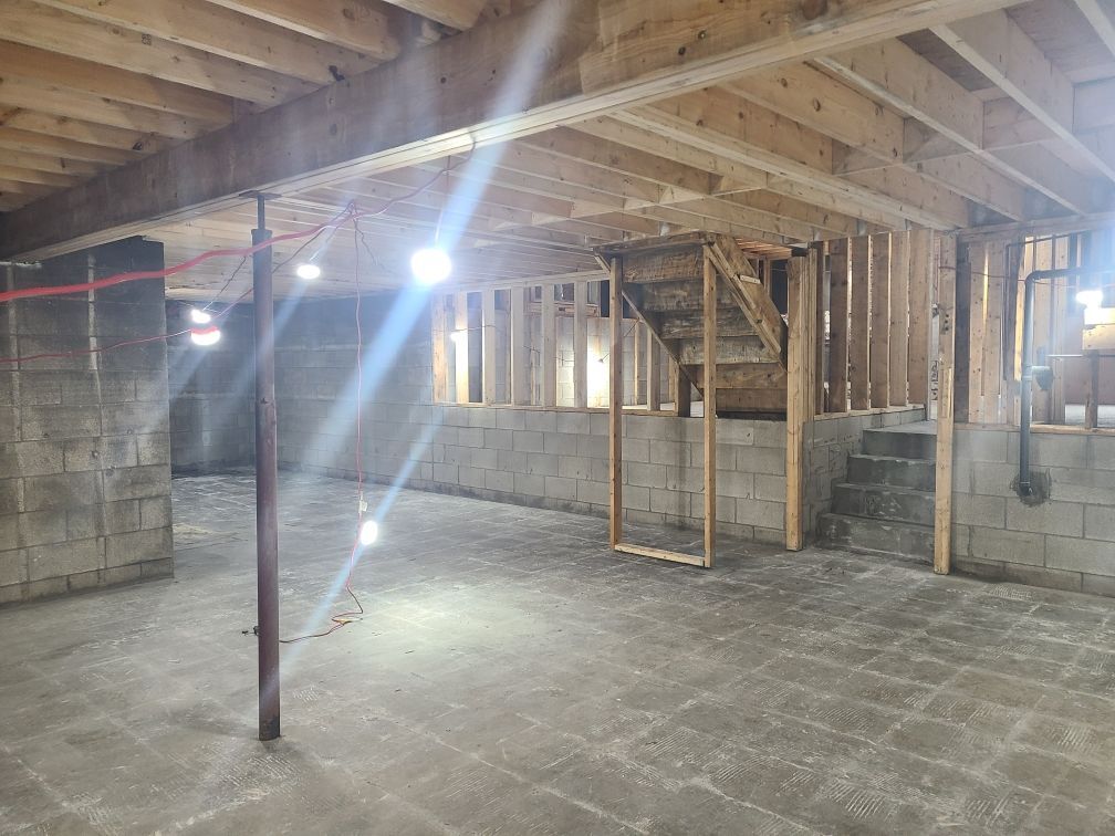 There is a staircase in the basement of a house under construction.