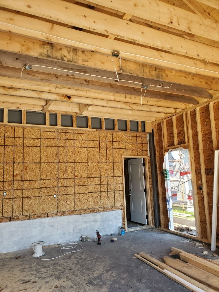 The inside of a building under construction with wooden beams and a door.