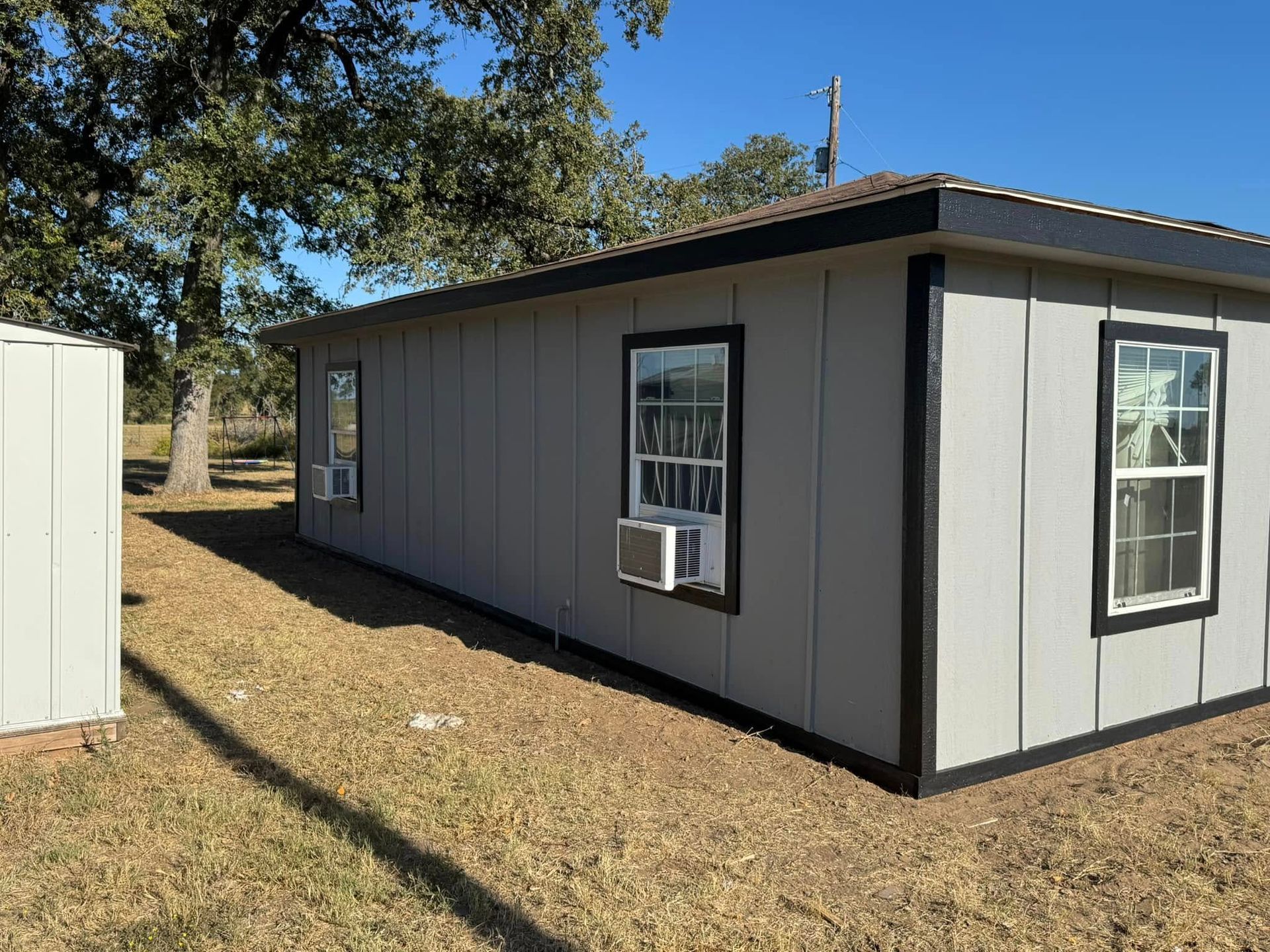 A mobile home with a window air conditioner on the side of it.