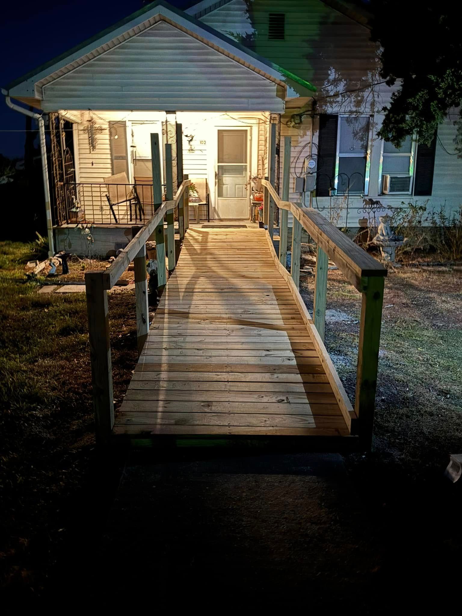 A wooden walkway leading to a house at night.