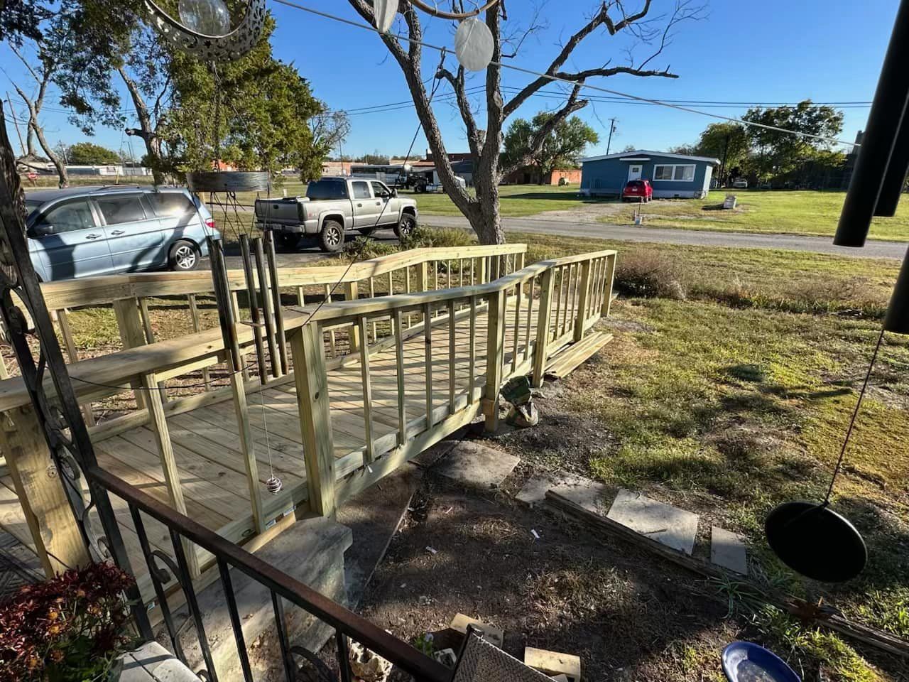 A wooden bridge is being built in the middle of a grassy field.