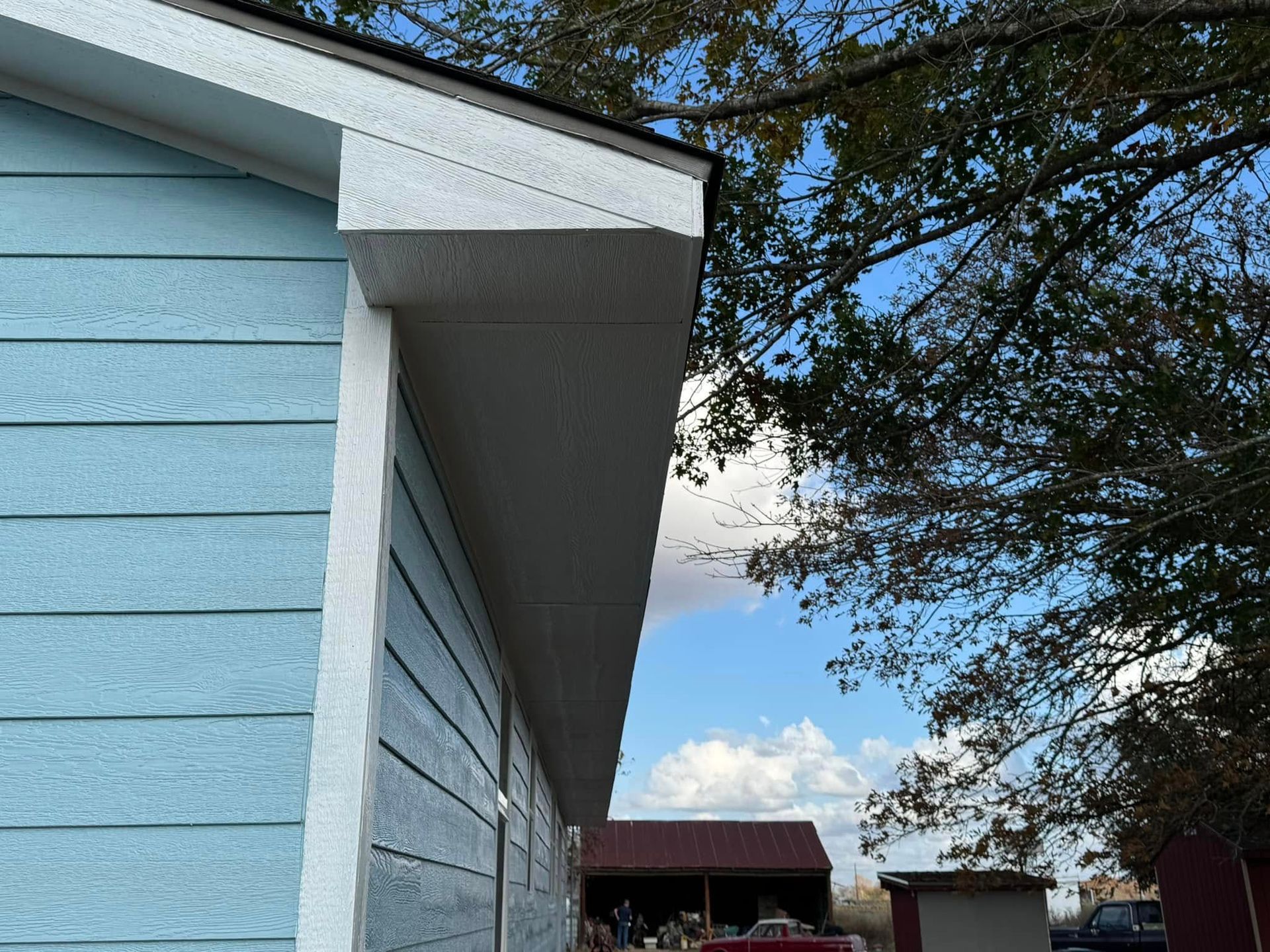 A blue and white house with a red truck parked in front of it.