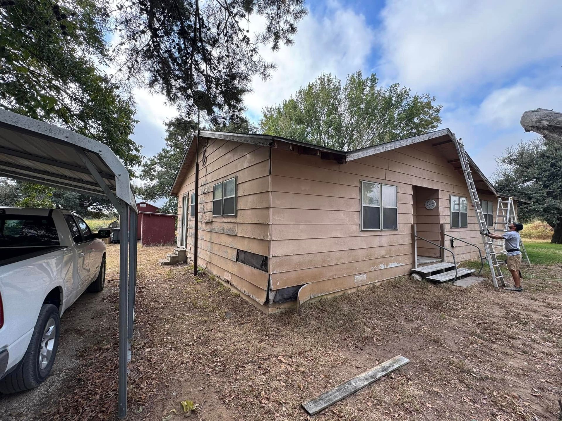 A man is standing in front of a house that is being painted.