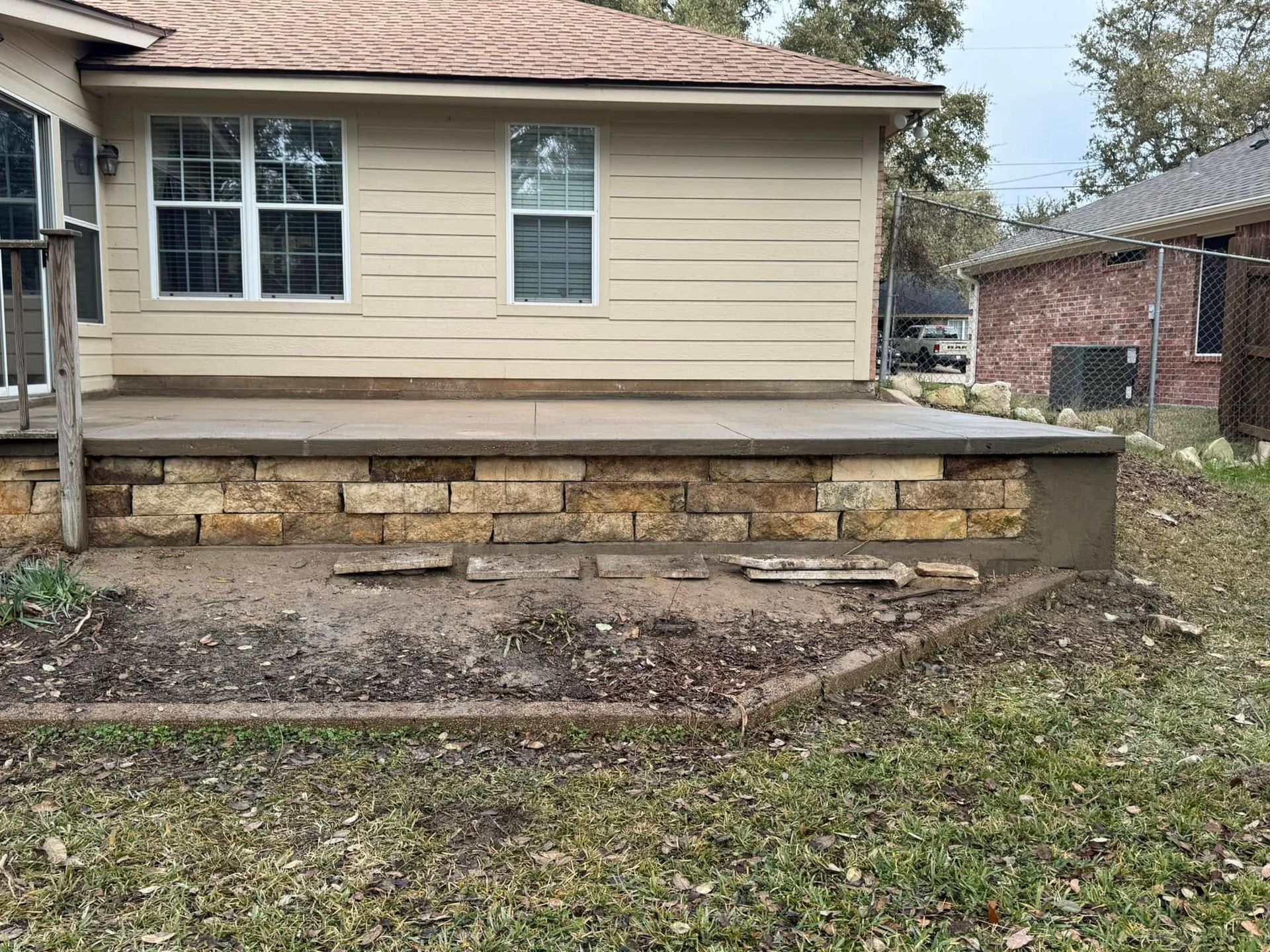 A brick wall is being built in front of a house.