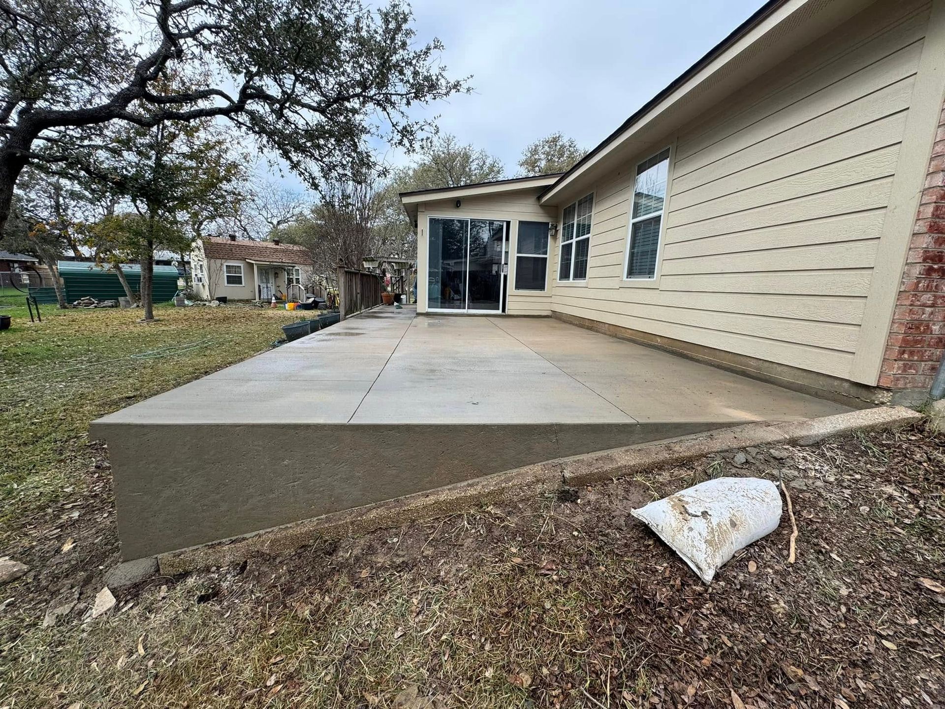 A concrete patio is being built in front of a house.