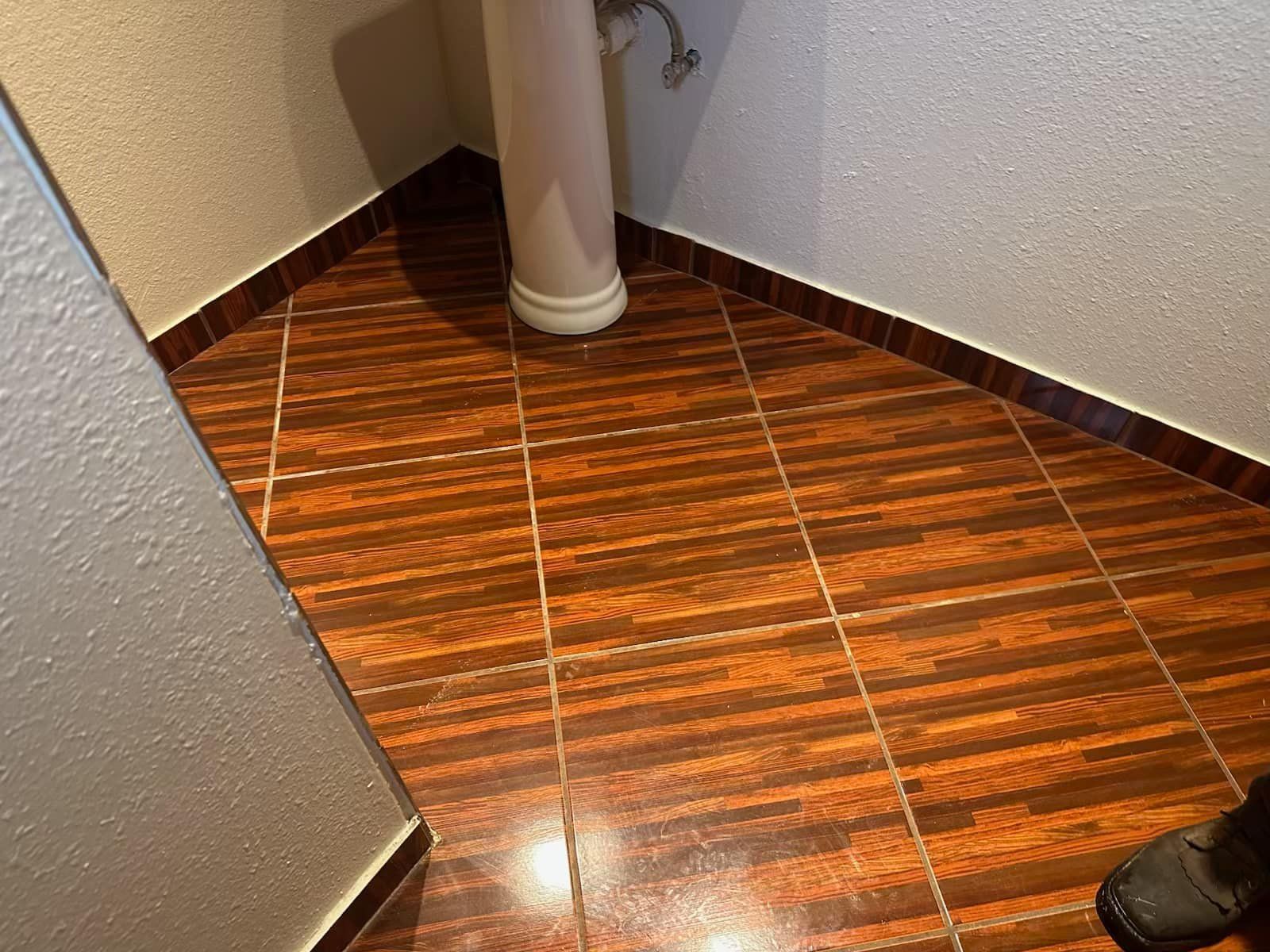 A bathroom with a pedestal sink and a tiled floor