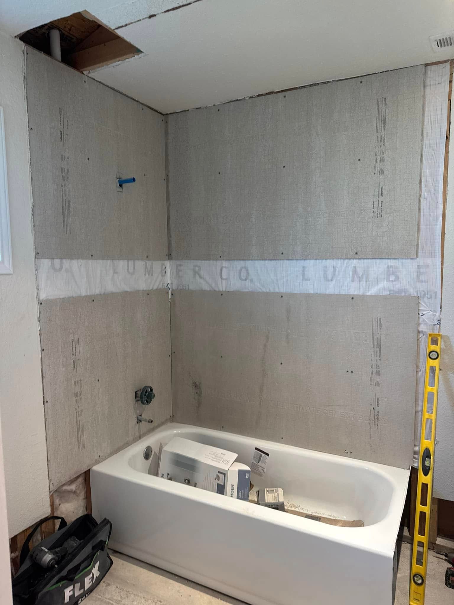 A bathtub is sitting in a bathroom under construction.