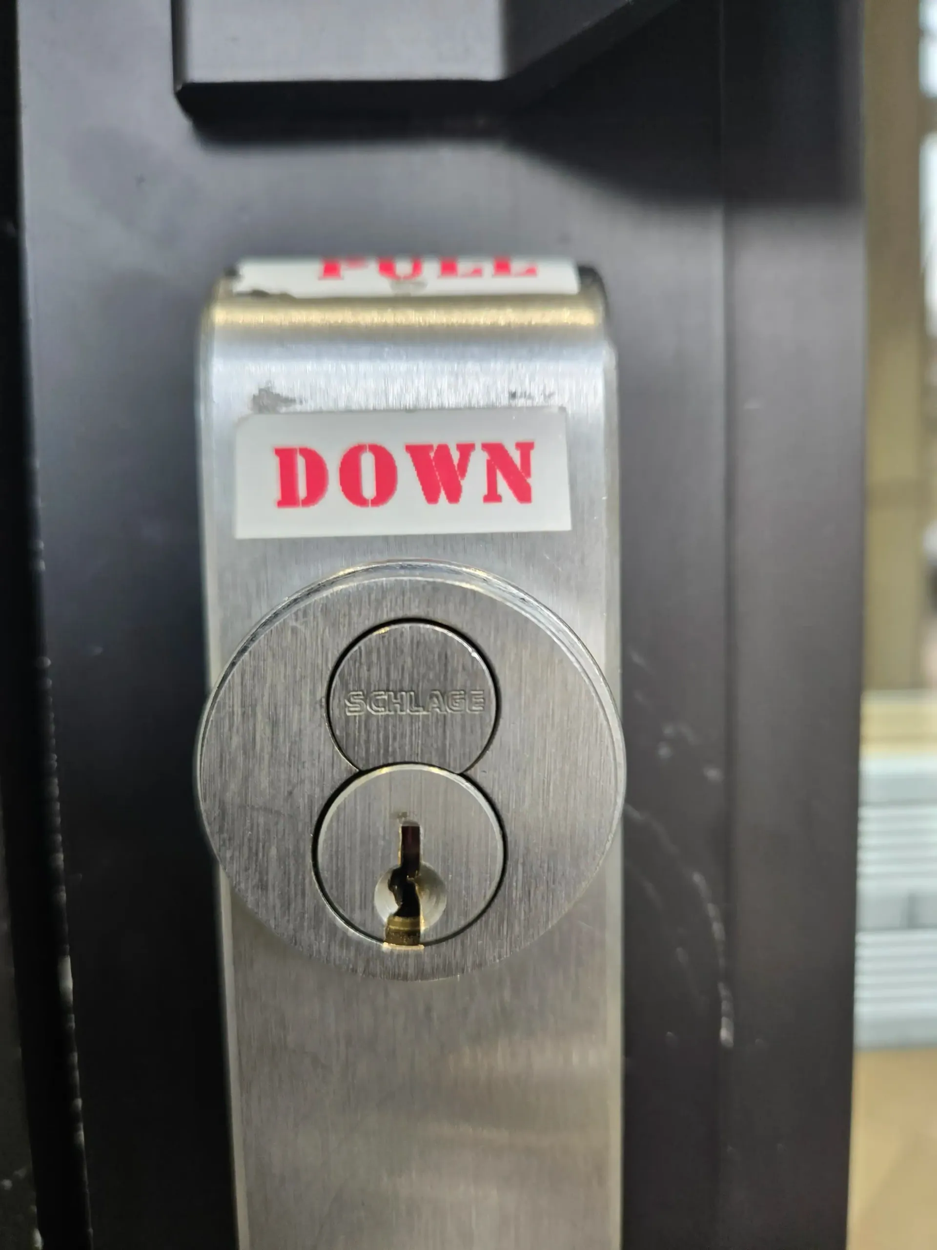 Close-up of a metal key switch labeled “DOWN” on a black panel.