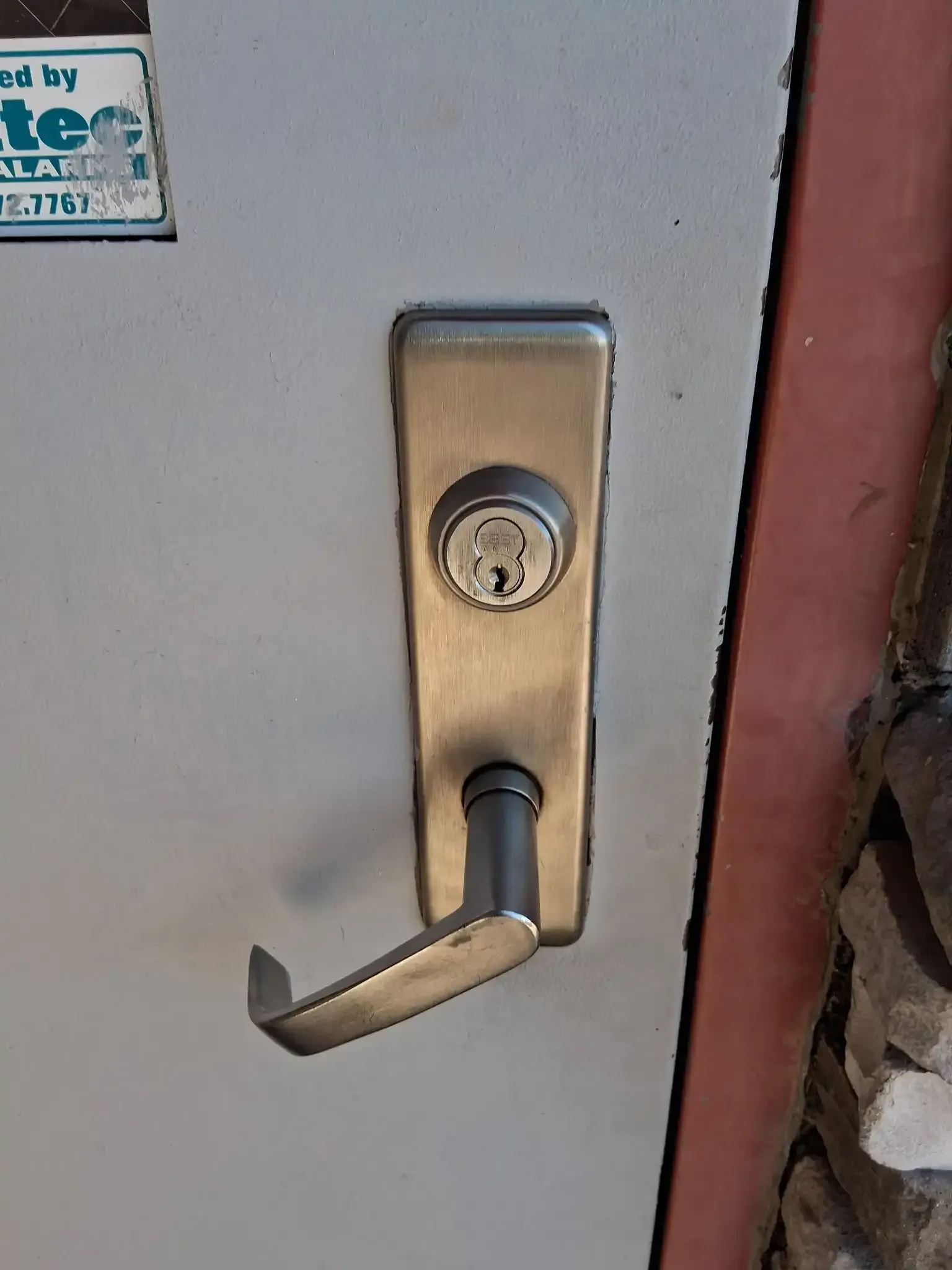 Brass door handle and lock on a light gray door, close-up.