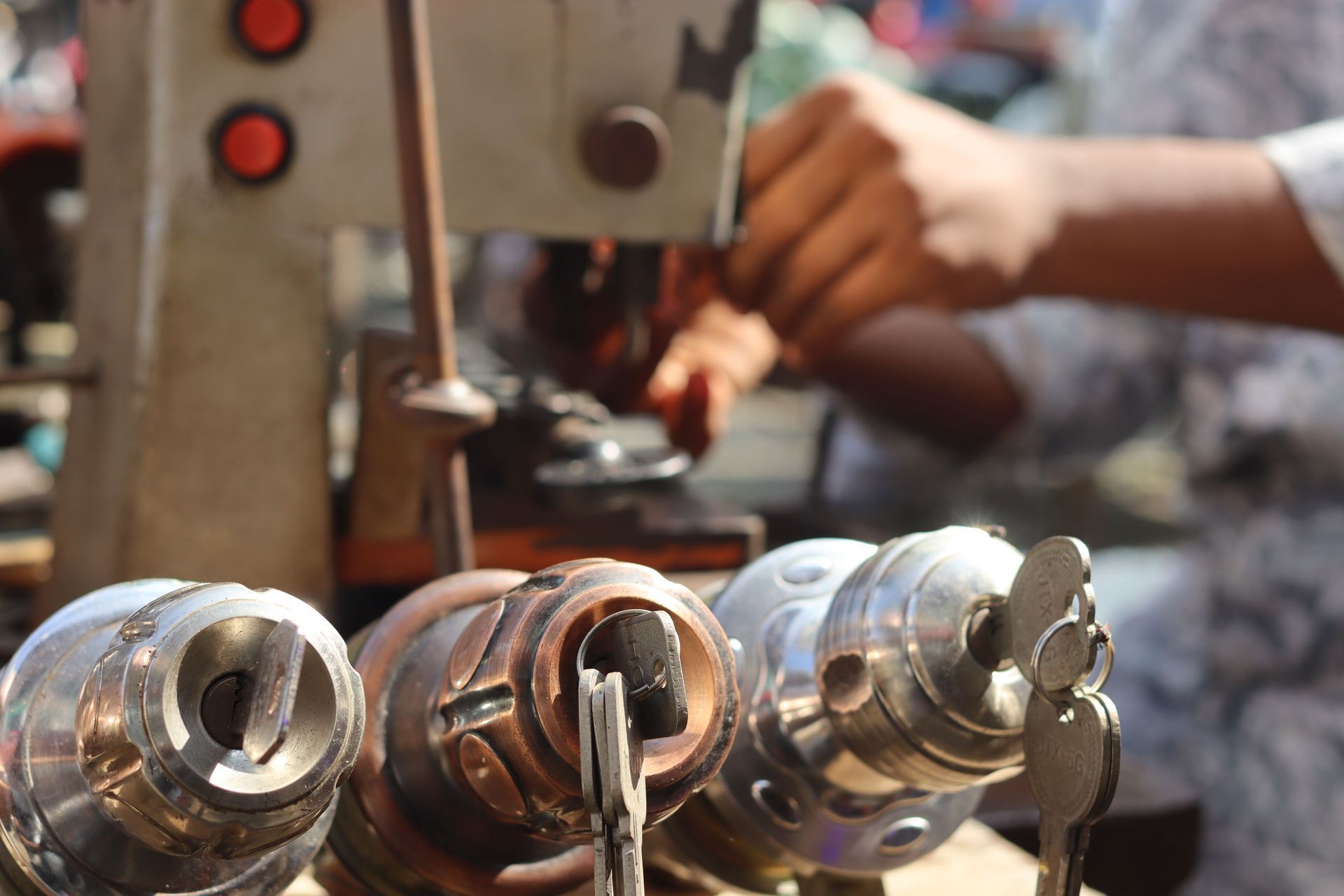 Hand pressing code buttons on a silver door keypad lock with a keyhole and handle