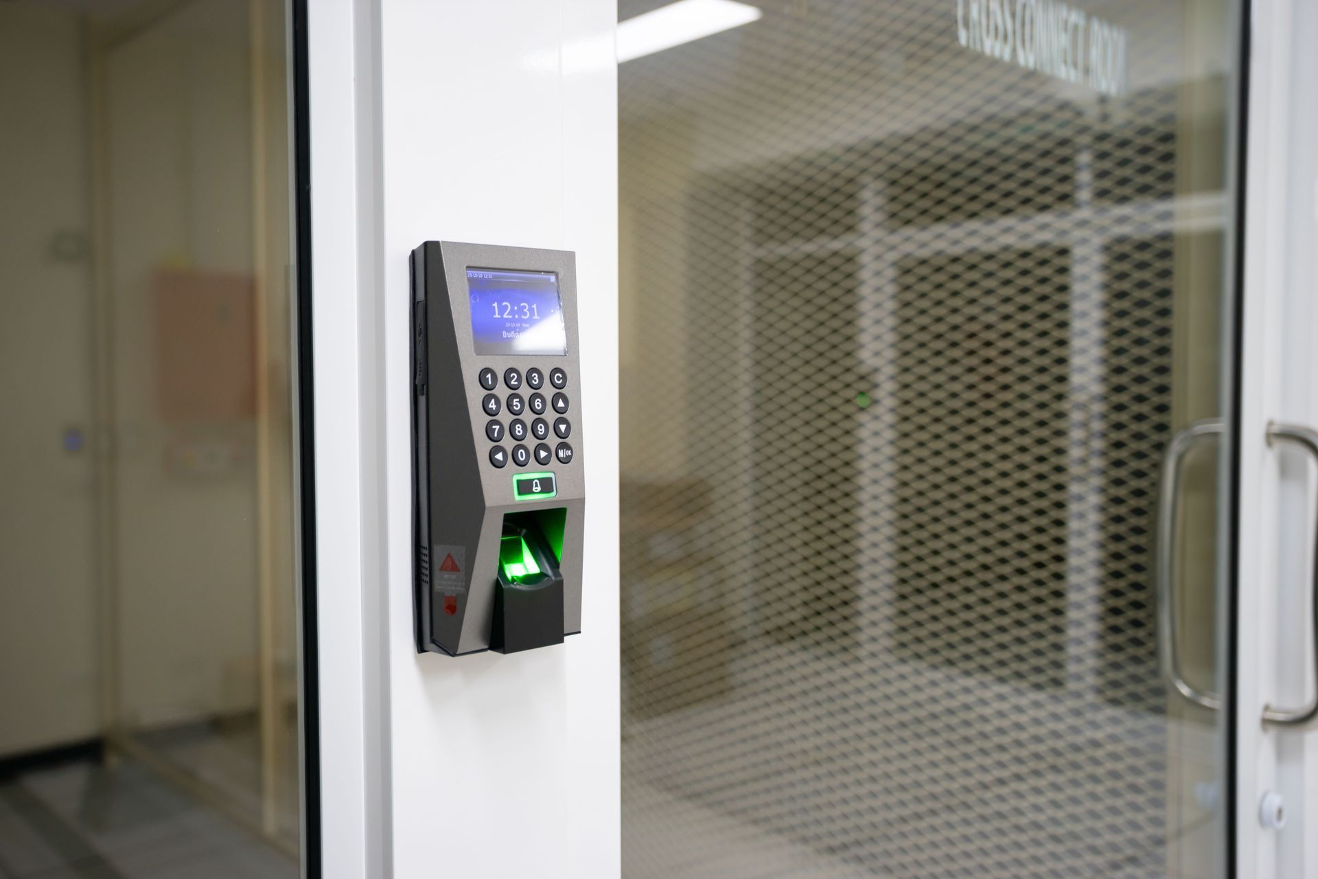 Fingerprint keypad access control mounted on a glass office door