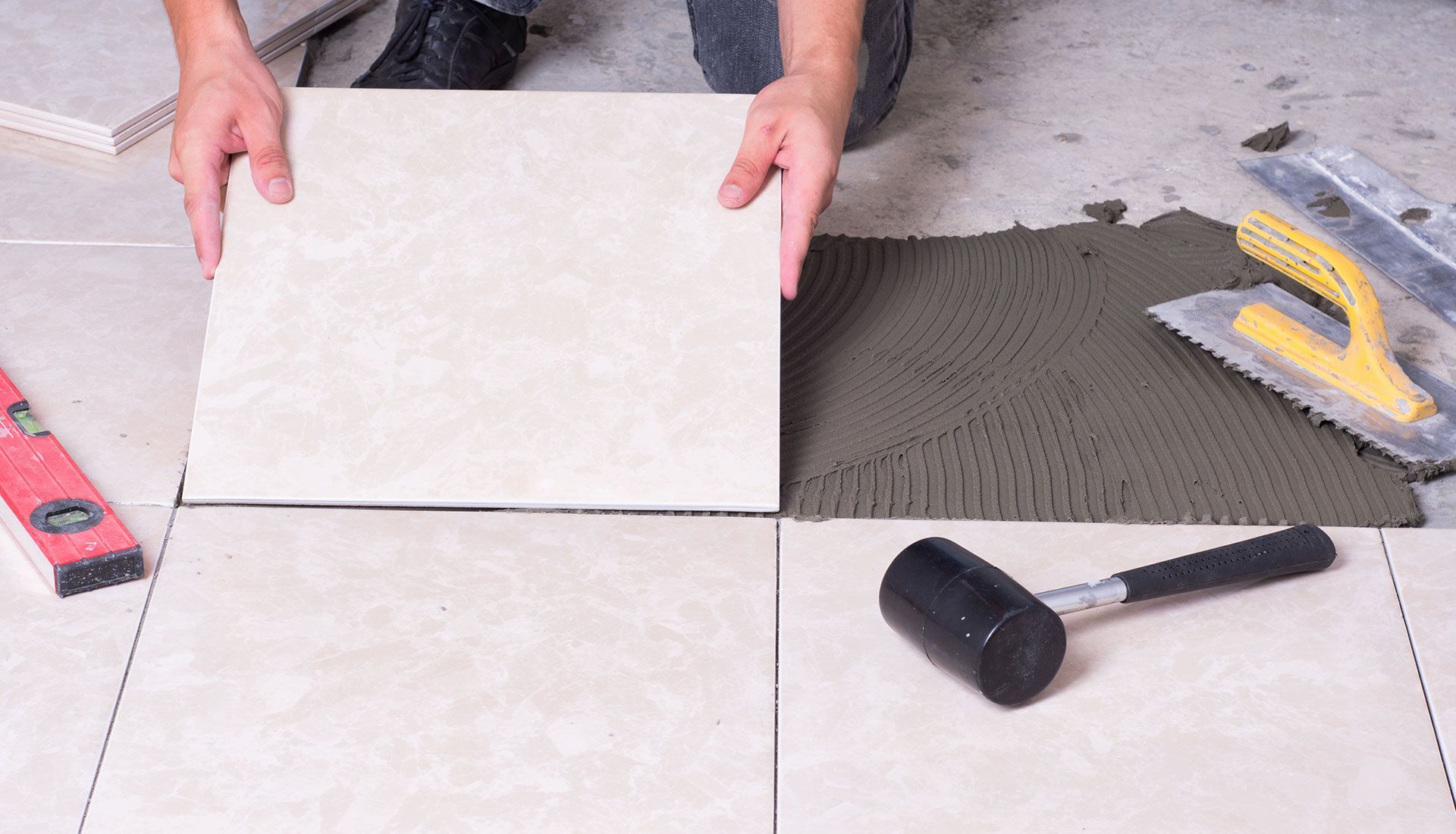 A person is laying a tile on the floor.