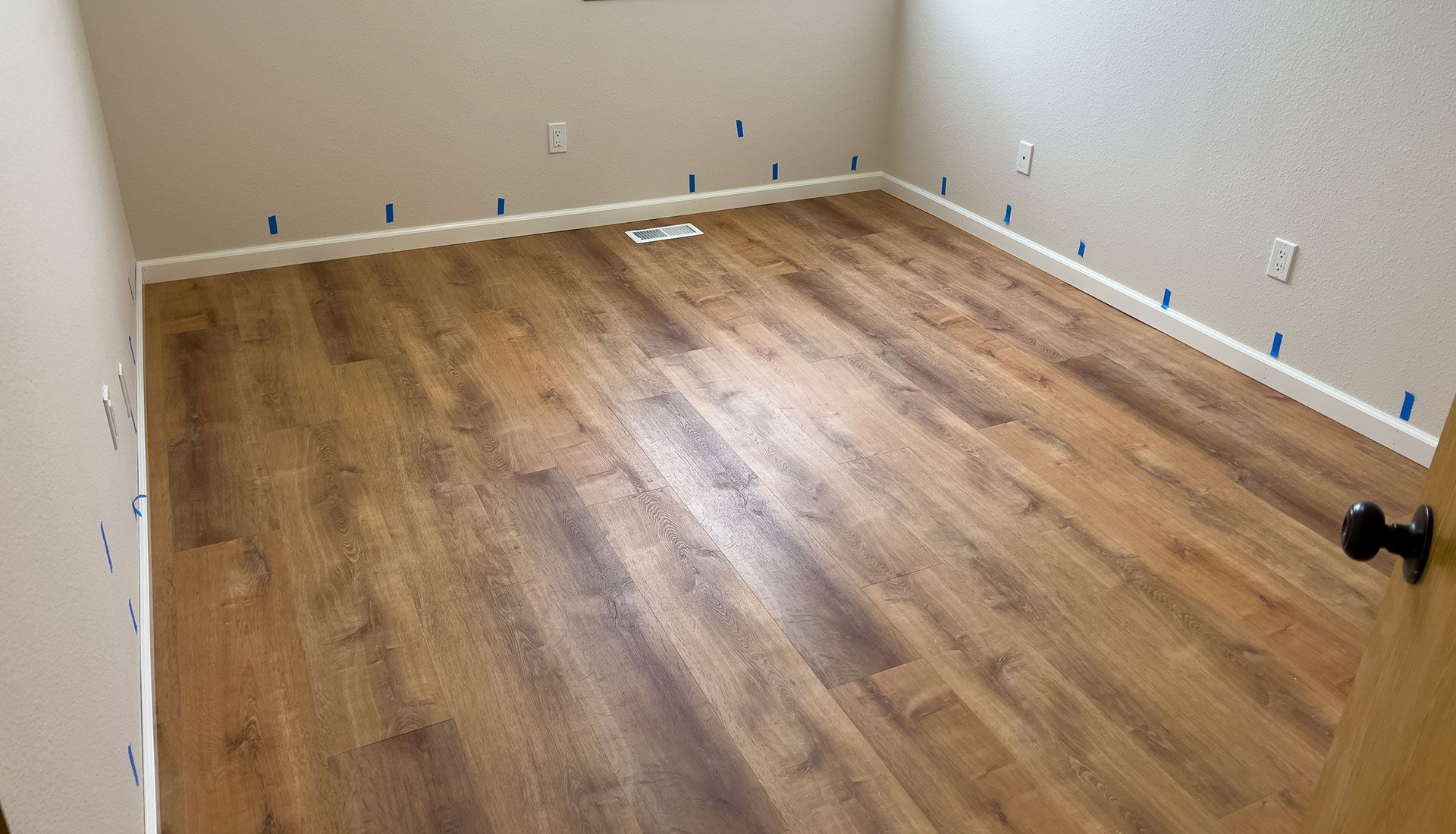 A room with a wooden floor and a door.