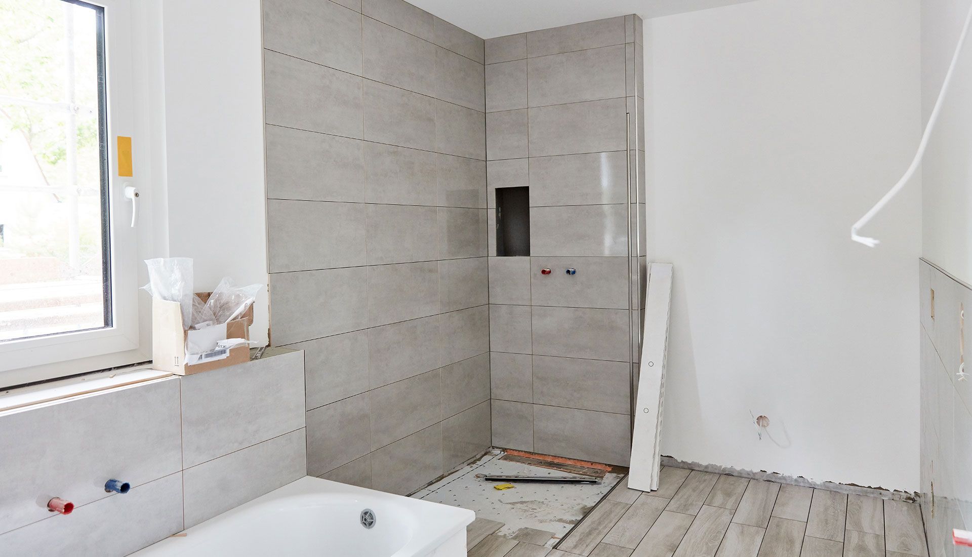 A bathroom under construction with a bathtub and shower.