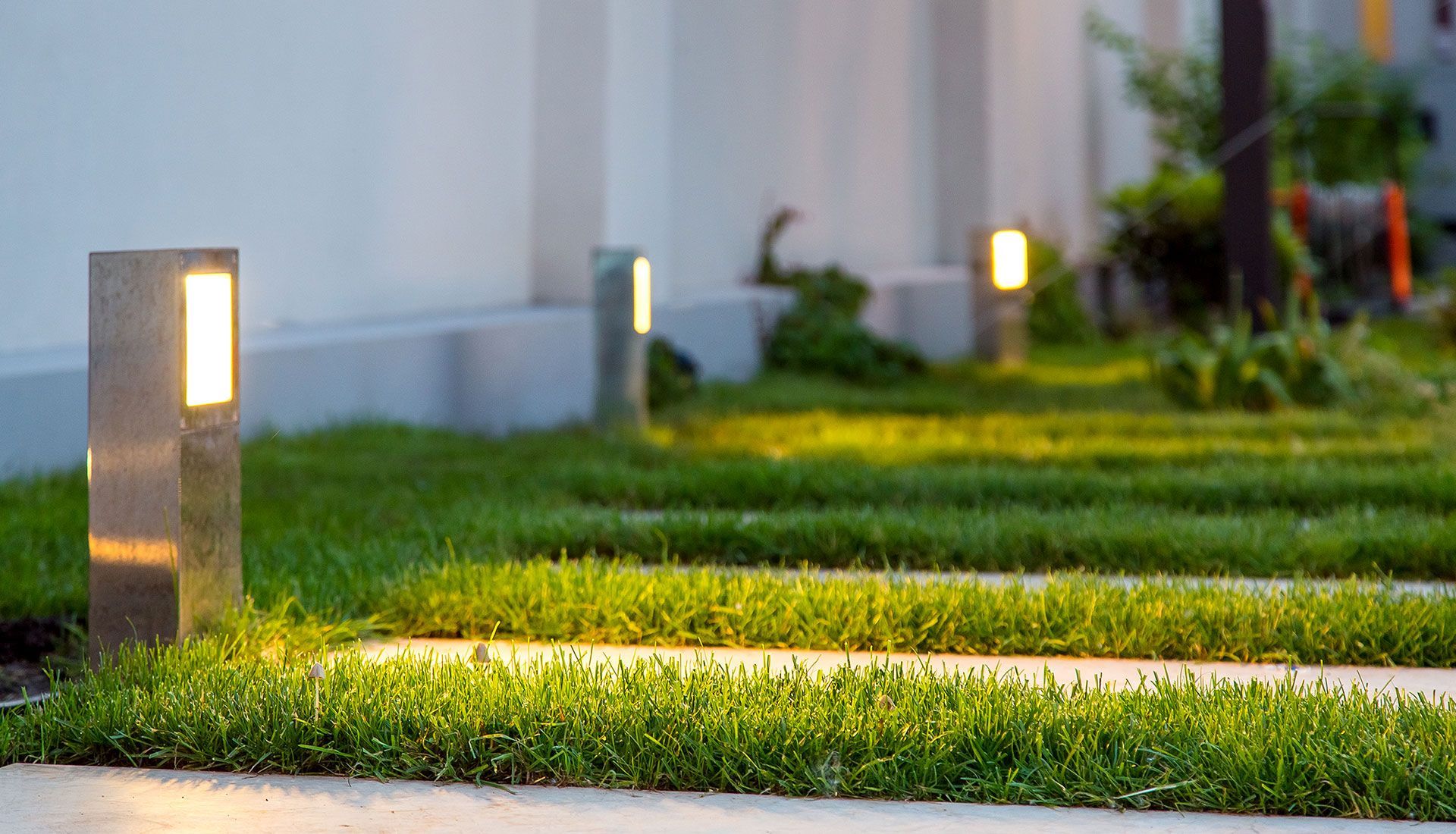 A row of lights sitting on top of a lush green lawn.