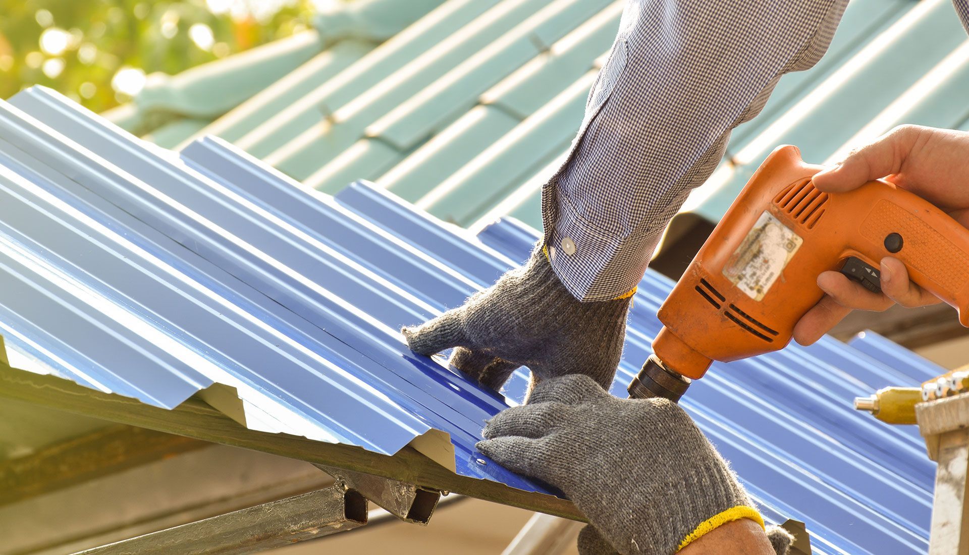 A person is working on a roof with a drill.
