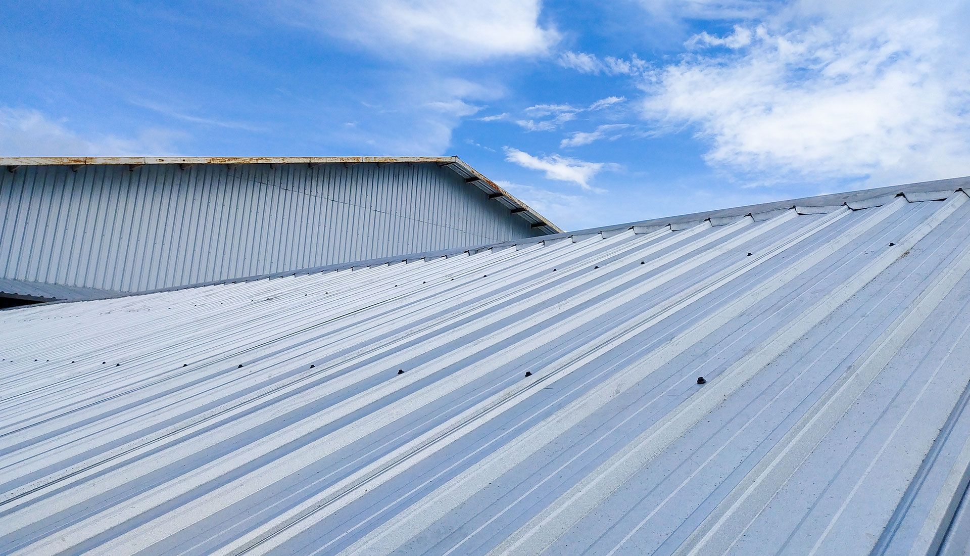 A metal roof with a blue sky in the background.